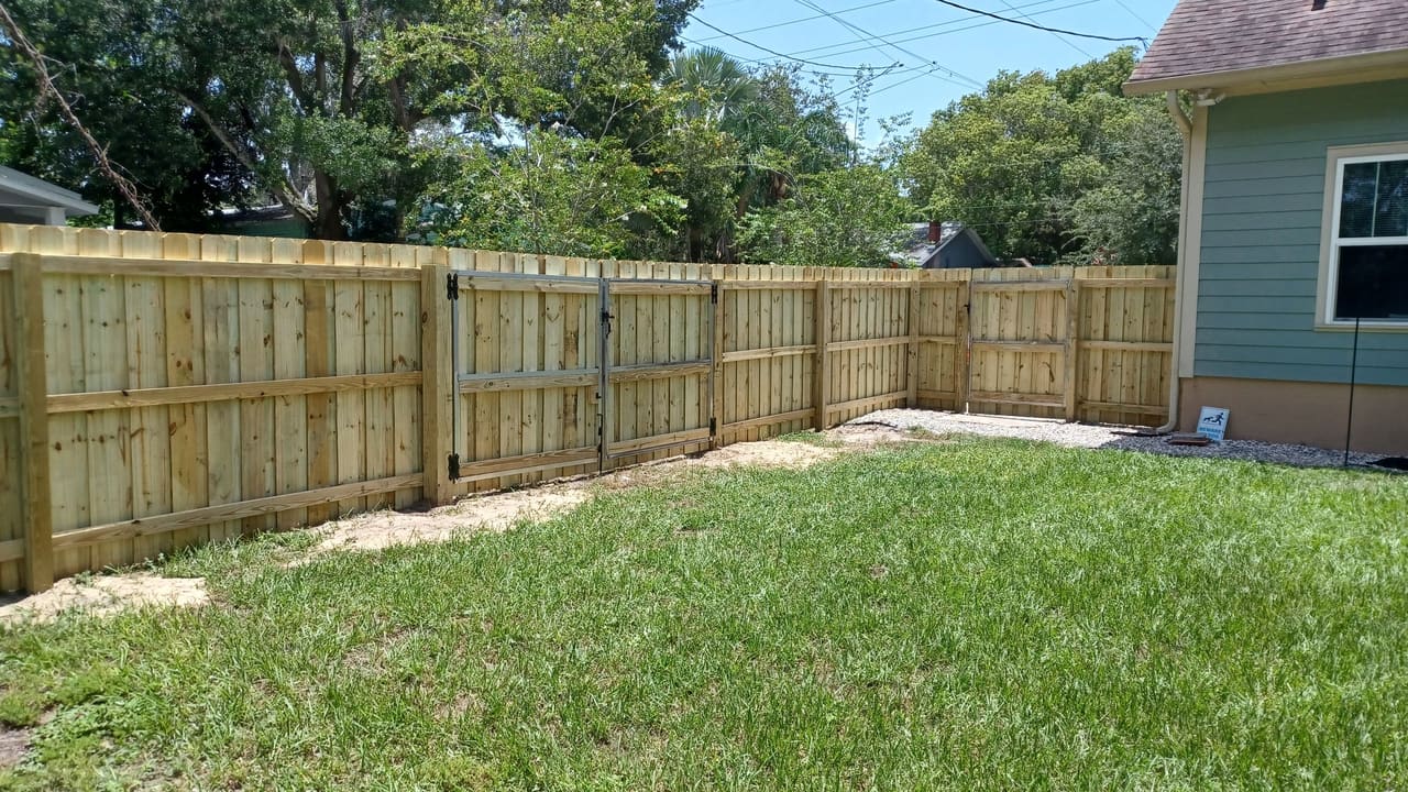 A wood privacy fence installed by Marquez Yera Fence along a green Orlando back yard